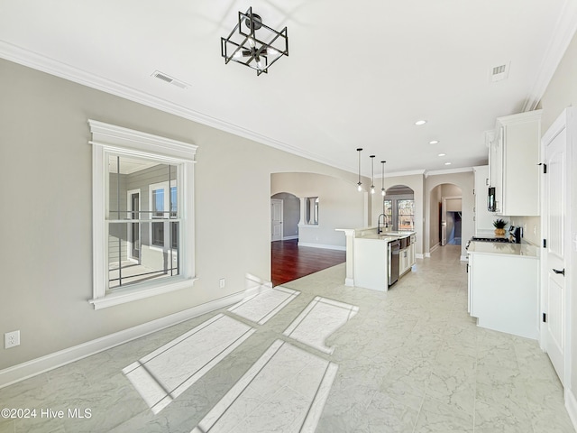 kitchen featuring sink, hanging light fixtures, a kitchen island with sink, white cabinets, and ornamental molding