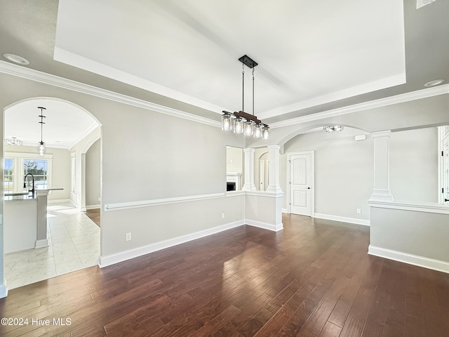 unfurnished dining area with hardwood / wood-style flooring, ornamental molding, and a tray ceiling