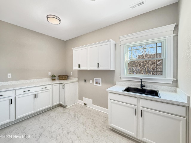 clothes washing area featuring hookup for an electric dryer, hookup for a washing machine, cabinets, and sink