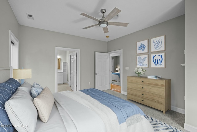 carpeted bedroom with connected bathroom and ceiling fan