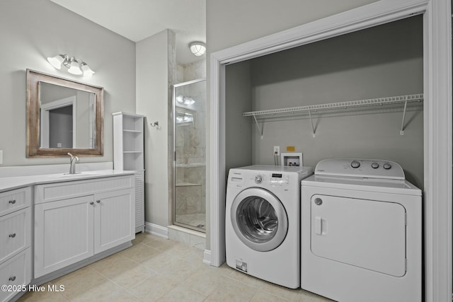 washroom featuring sink, light tile patterned floors, and separate washer and dryer