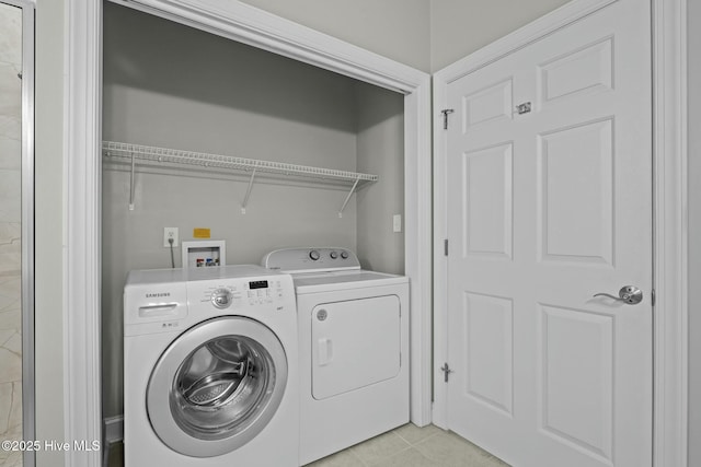 laundry area featuring light tile patterned flooring and washer and clothes dryer