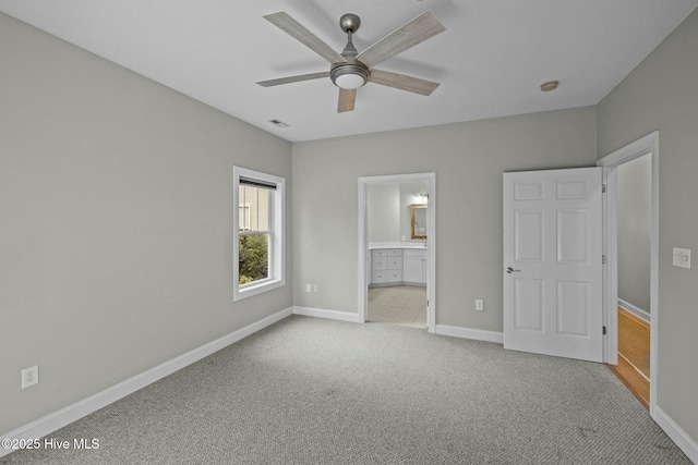 unfurnished bedroom with ensuite bathroom, light colored carpet, and ceiling fan