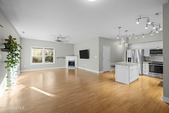 kitchen featuring a center island, appliances with stainless steel finishes, tasteful backsplash, and white cabinetry