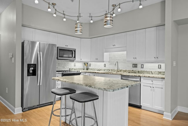 kitchen with appliances with stainless steel finishes, white cabinetry, and sink