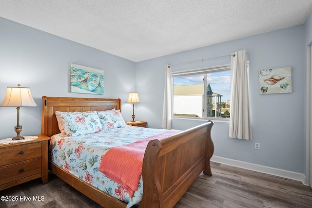 bedroom with a textured ceiling and dark wood-type flooring