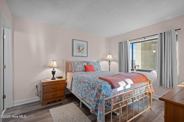 bedroom featuring a textured ceiling and dark wood-type flooring