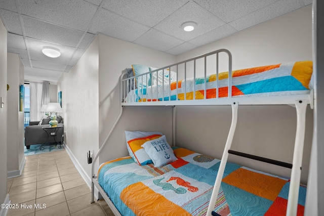 tiled bedroom featuring a drop ceiling