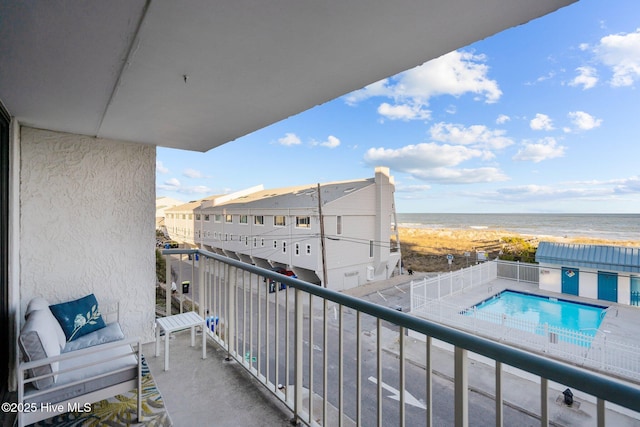 balcony featuring a water view and a view of the beach