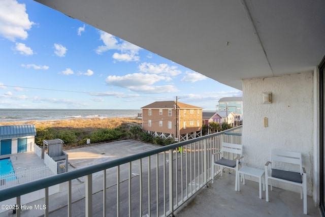 balcony featuring a water view and a view of the beach