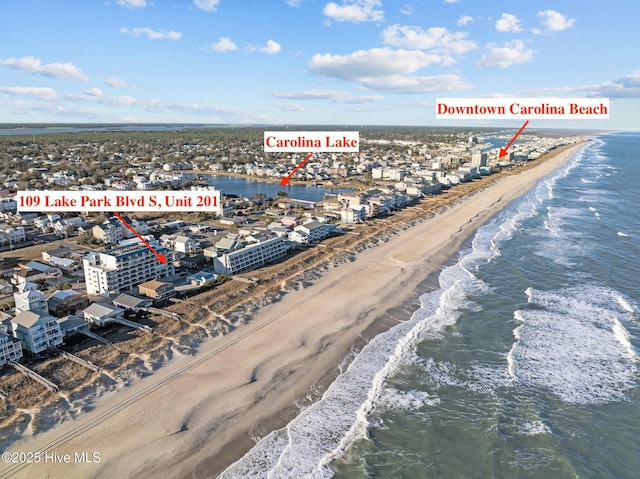 drone / aerial view featuring a water view and a beach view