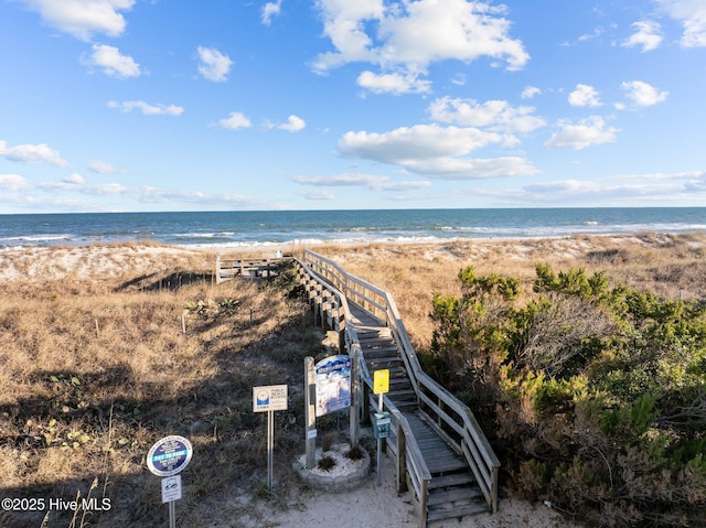 drone / aerial view featuring a water view and a beach view