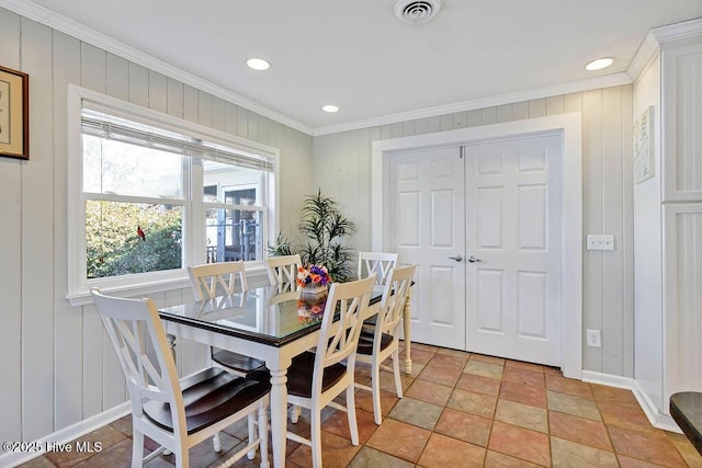 dining space with light tile patterned floors and crown molding