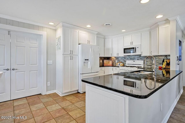 kitchen featuring white cabinetry, kitchen peninsula, white appliances, crown molding, and sink