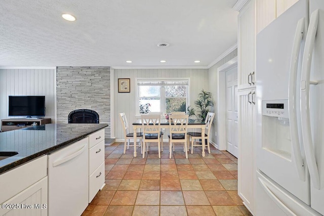 kitchen featuring light tile patterned floors, white cabinetry, white appliances, a fireplace, and ornamental molding