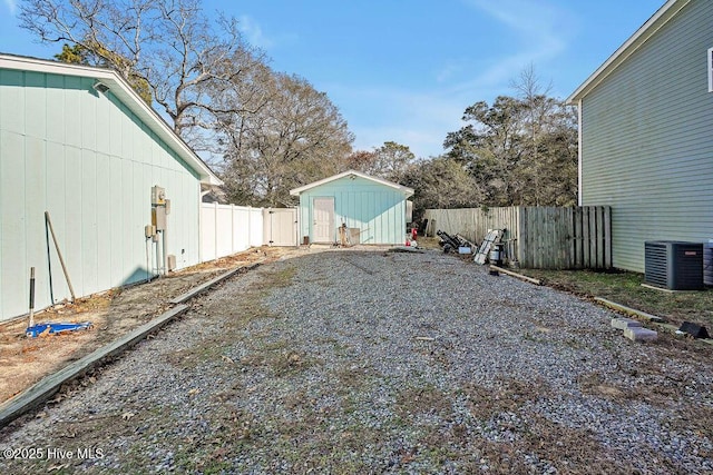 view of yard featuring a storage unit and central air condition unit