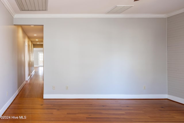 unfurnished room with hardwood / wood-style flooring and crown molding