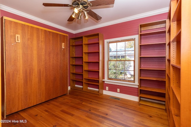 unfurnished bedroom featuring hardwood / wood-style flooring, ceiling fan, and ornamental molding