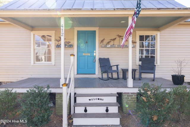 view of exterior entry with a porch