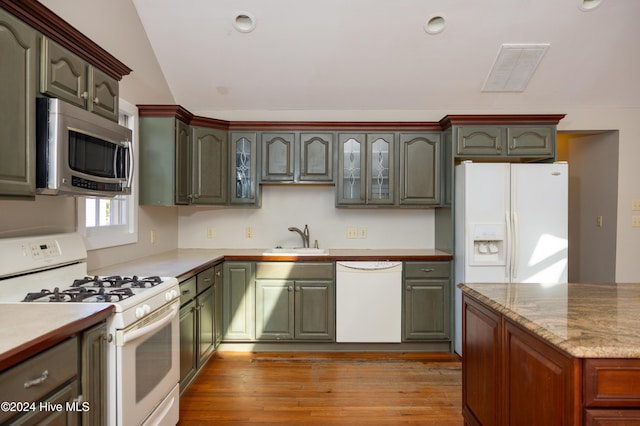 kitchen featuring sink, light wood-type flooring, lofted ceiling, white appliances, and green cabinetry