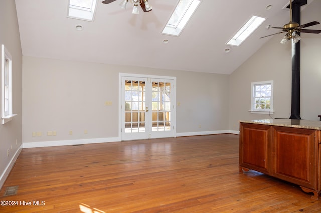 unfurnished living room featuring wood-type flooring, french doors, high vaulted ceiling, and ceiling fan