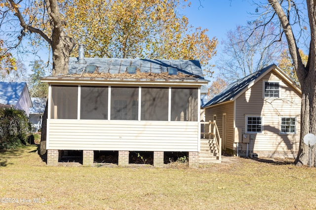 back of house with a yard and a sunroom