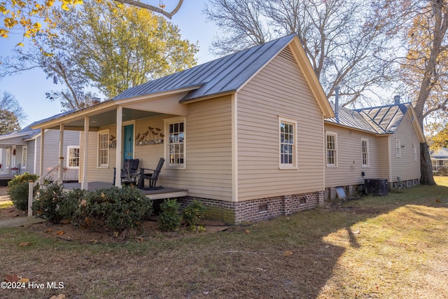 view of front of property featuring central AC, a porch, and a front yard