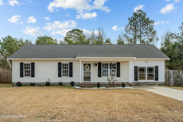 ranch-style home featuring covered porch and a front lawn