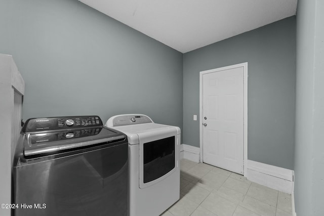 washroom featuring independent washer and dryer and light tile patterned floors