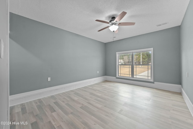 spare room with ceiling fan, a textured ceiling, and light hardwood / wood-style flooring