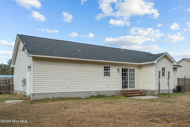 back of house with a yard and central AC