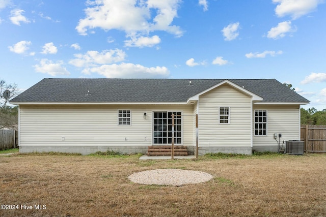 rear view of property with a lawn and central AC