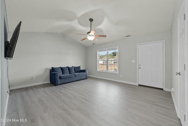 unfurnished living room featuring light wood-type flooring, vaulted ceiling, and ceiling fan