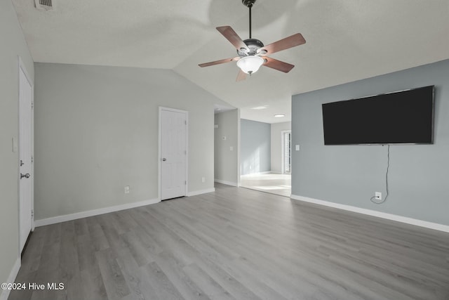 unfurnished living room featuring ceiling fan, light hardwood / wood-style floors, and vaulted ceiling