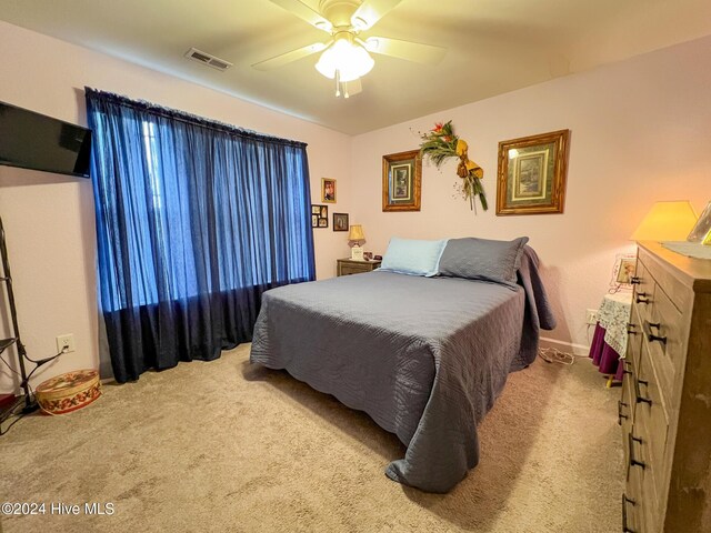 bedroom featuring ceiling fan and light carpet