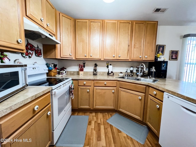 kitchen featuring sink, white appliances, and light hardwood / wood-style flooring