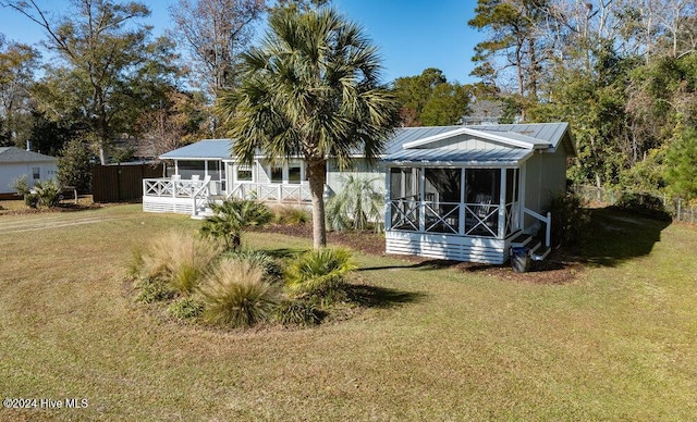 back of house featuring a yard and a sunroom