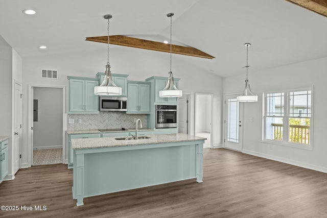 kitchen featuring sink, a center island with sink, pendant lighting, stainless steel appliances, and light stone countertops