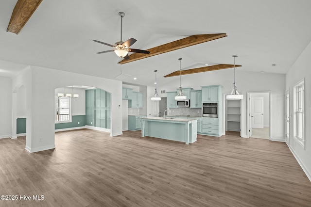 kitchen featuring a kitchen island with sink, decorative light fixtures, light hardwood / wood-style flooring, and stainless steel appliances