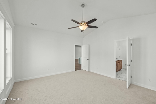 unfurnished bedroom with light carpet, ensuite bath, vaulted ceiling, and ceiling fan