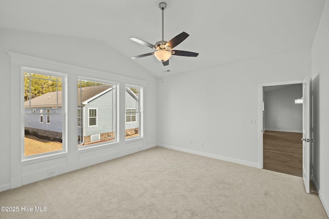 carpeted empty room with vaulted ceiling and ceiling fan