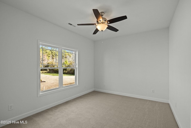 carpeted spare room with ceiling fan