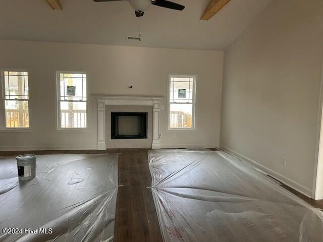 unfurnished living room with ceiling fan, dark wood-type flooring, and vaulted ceiling