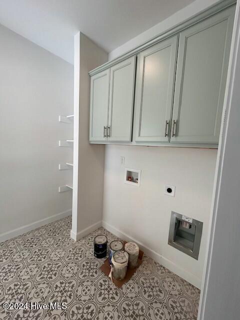 clothes washing area with electric dryer hookup, cabinets, and washer hookup