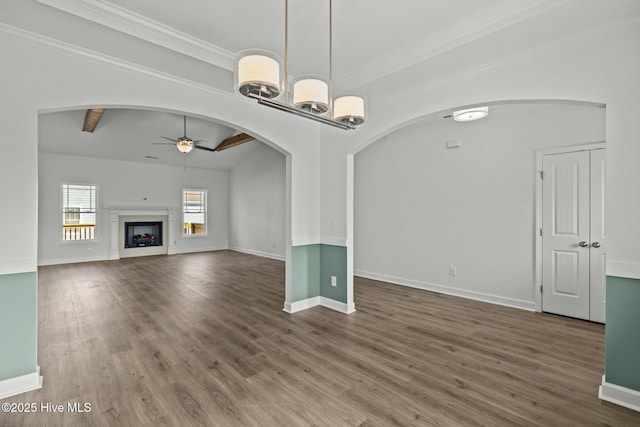 unfurnished living room with hardwood / wood-style flooring, ceiling fan, crown molding, and beamed ceiling