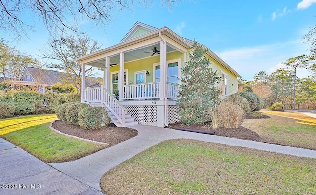 view of front of house with ceiling fan, a porch, and a front yard