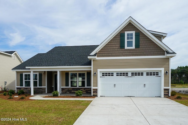 craftsman-style home featuring a porch, a garage, and a front yard