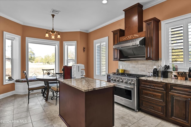 kitchen featuring decorative light fixtures, a kitchen island, high end range, and ornamental molding