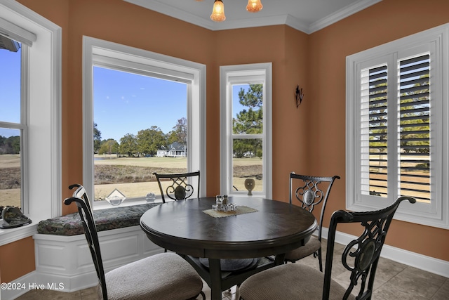 tiled dining area with an inviting chandelier, a wealth of natural light, and ornamental molding