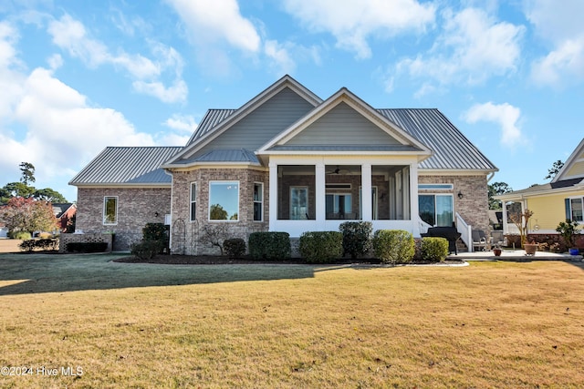 view of front facade with a sunroom and a front lawn